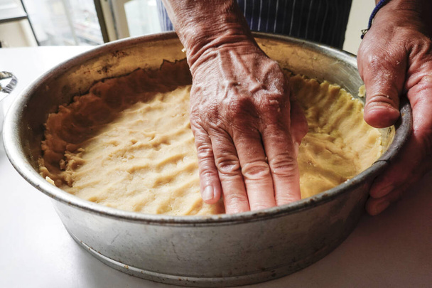 Egy nő tésztát présel egy quiche formába. - Fotó, kép