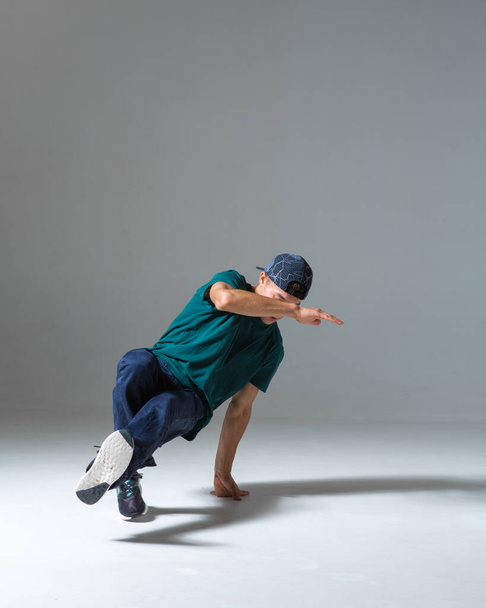 Cool guy breakdancer dancing lower break dance isolated on gray background. Breakdance poster - Фото, зображення