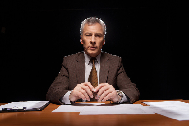 Hombre en ropa formal sentado en su lugar de trabajo
 - Foto, Imagen