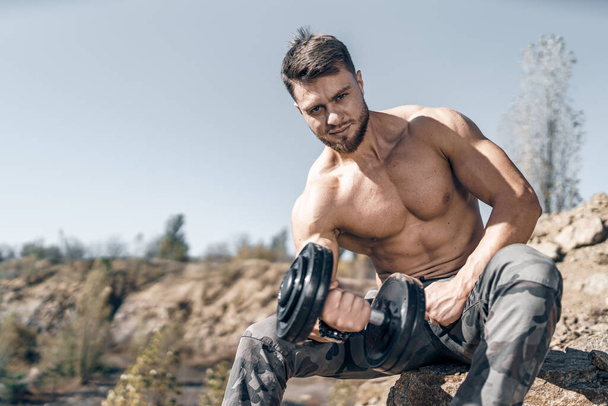 Heavy training in a quarry. Intense workout. Strong attractive bodybuilder. Lifestyle. Rock landscape. - Fotoğraf, Görsel
