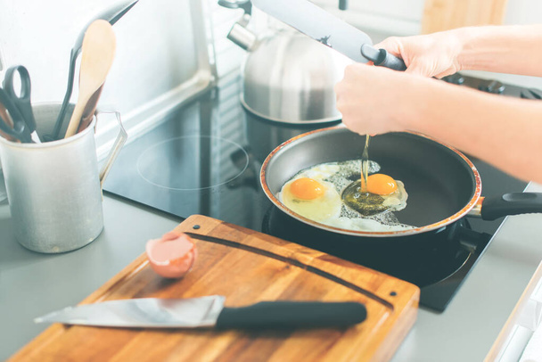 Prosessi paistamiseen munat paistinpannu keittiö asetelma maalaismainen astiat pöytä Ware veitsi leikkuulauta pöytälevy kuva - Valokuva, kuva