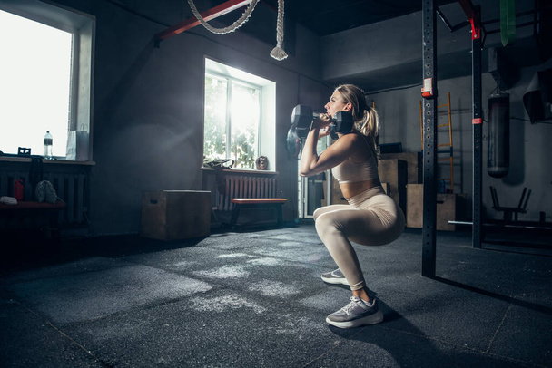 The female athlete training hard in the gym. Fitness and healthy life concept. - Valokuva, kuva