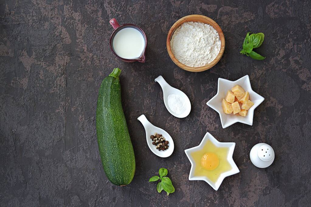 Ingredients for cooking zucchini wafers on a dark concrete background. Top view, copy space. Italian food. Healthy food. - Foto, imagen