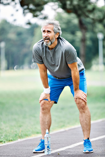 портрет пожилого человека, занимающегося спортом и бегущего на открытом воздухе - Фото, изображение