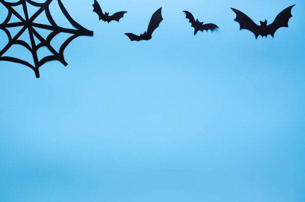 Happy Halloween holiday background with craft paper in the form of cobwebs and bats on blue. Halloween holiday celebration with decoration. - Photo, Image