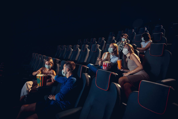 Cinema, movie theatre during quarantine. Coronavirus pandemic safety rules, social distance during movie watching - Photo, Image