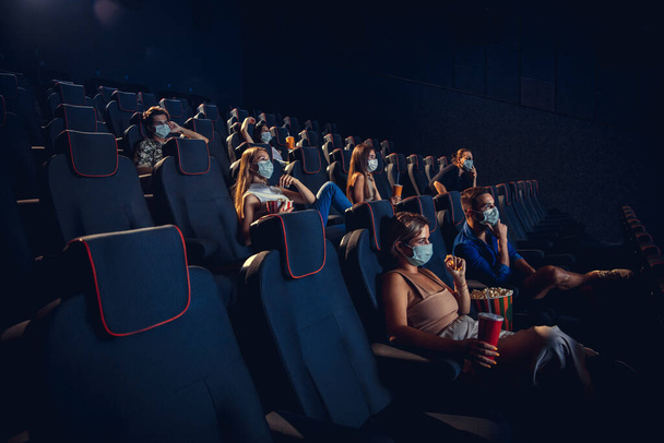 Cinema, movie theatre during quarantine. Coronavirus pandemic safety rules, social distance during movie watching - Φωτογραφία, εικόνα