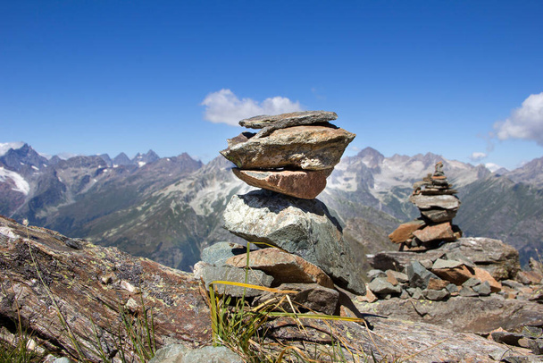 torre ripiegata da un uomo dalle pietre di montagna sullo sfondo di un paesaggio montano - Foto, immagini