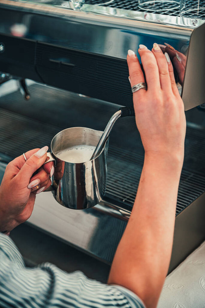 Barkeeper bereitet heiße Milch auf Kaffeemaschine zu - Foto, Bild