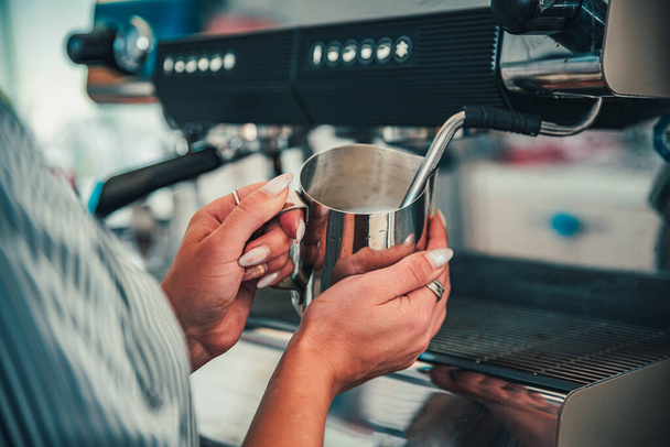 bartender preparing hot milk on coffee machine - Foto, afbeelding
