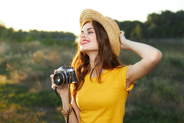 mosolygós nő fogja a kezét a kalap kamera természet friss levegő - Fotó, kép