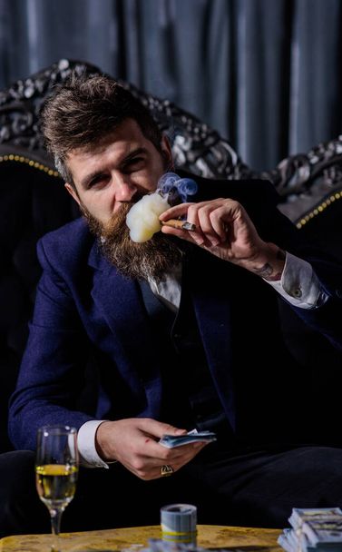 smoking gangster holding dollar in vintage luxury room - Foto, imagen