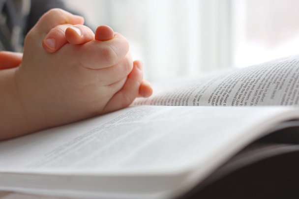 τα χέρια του μικρού παιδιού που προσεύχεται για την Αγία Γραφή - Φωτογραφία, εικόνα