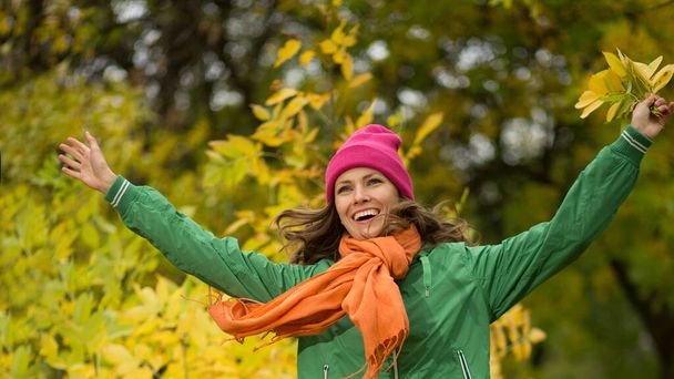  Carefree young woman in autumn park enjoying good warm weather - Foto, Bild