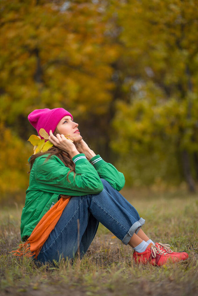  Carefree young woman in autumn park enjoying good warm weather - Foto, Bild