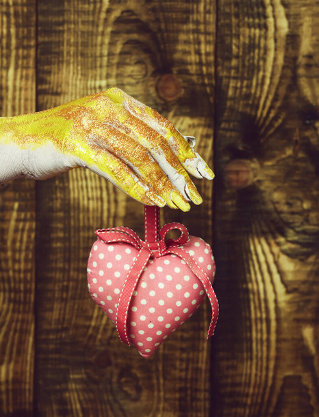 female hand holding valentine heart on brown vintage studio background, selective focus - Foto, immagini