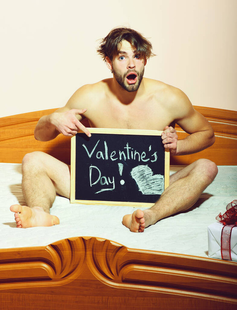 surprised bearded macho sexy man on pink wall background, copy space - Фото, изображение