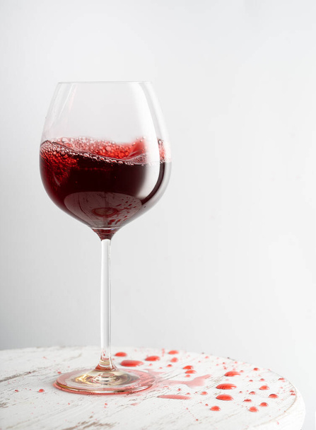 Glass of red wine on table with spilled drink - Foto, immagini