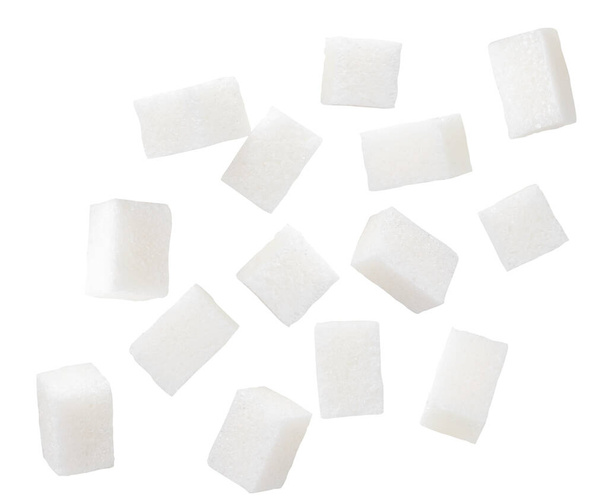 Cubos de açúcar refinado estão voando sobre um fundo branco. Isolados - Foto, Imagem
