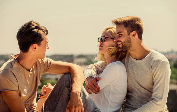 Friends relaxing on roof. Carefree friends. True friendship. Being sincere with closest people. Men and woman talking sky background. Spending time with friends. Summer vacation. Discussing ideas - Valokuva, kuva