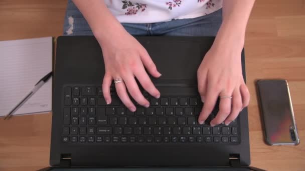 Persoon die werkt op een laptop op een houten vloer - Video