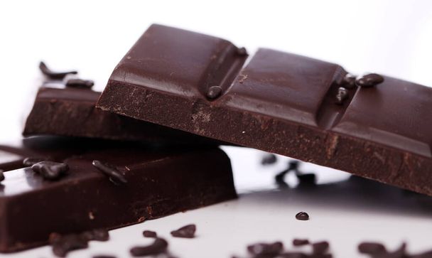 Kawałki czarnej czekolady na białym tle - Zdjęcie, obraz