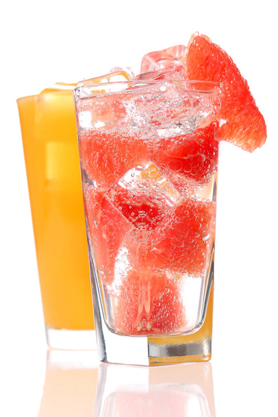 Sinaasappel en grapefruitsap op een heldere tafel op een kleurrijke achtergrond - Foto, afbeelding