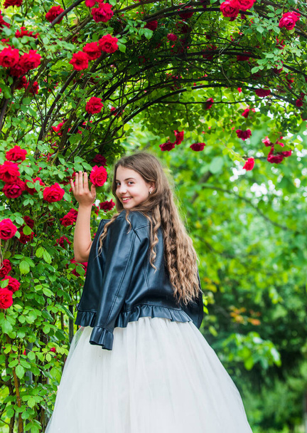 Trendy girl fancy dress and leather jacket in roses garden, stylish princess concept - Fotoğraf, Görsel