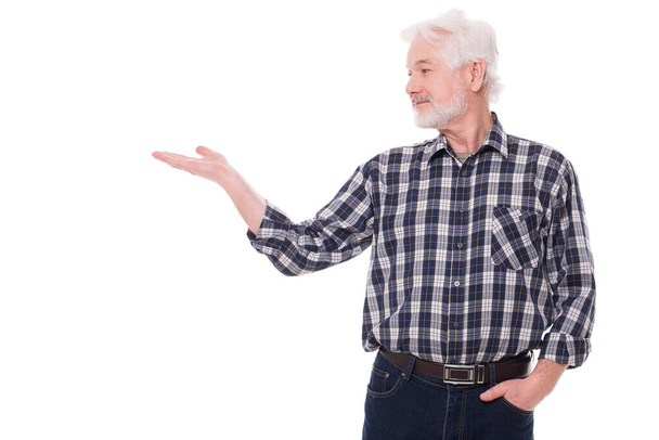 Komea vanha mies, jolla on harmaa parta, näyttää jotain eristettyä valkoisella taustalla - Valokuva, kuva