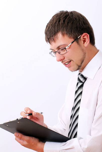 Happy businessman in glasses is filling documents - Photo, image