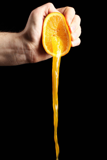 Свежий апельсиновый сок на черном фоне - Фото, изображение
