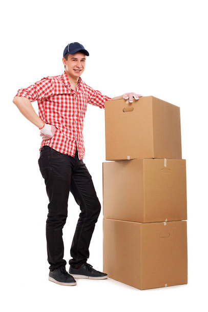 Handsome young caucasian courier with brown box isolated over white background - Valokuva, kuva