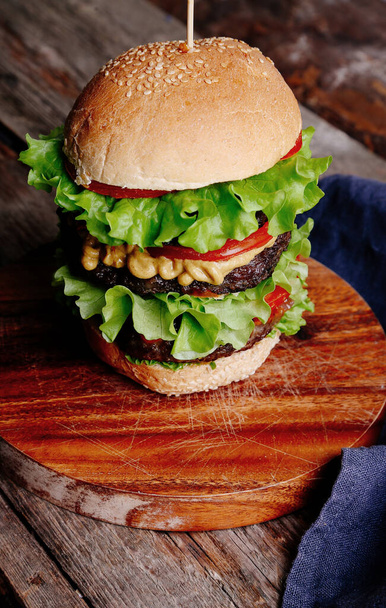 Heerlijke hamburger op de houten tafel - Foto, afbeelding