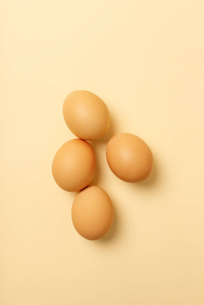 Four eggs on a vanilla background - 写真・画像