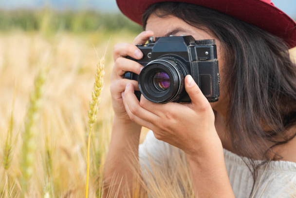 Retrato de una joven hispana con espíritu artista tomando fotos con una cámara analógica - Hipster girl tomando fotos de la naturaleza con su cámara vintage - Foto, Imagen