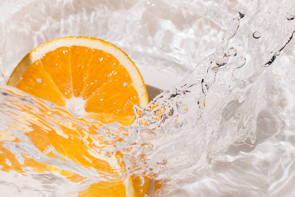 Tranches d'une éclaboussure d'orange dans l'eau - Photo, image