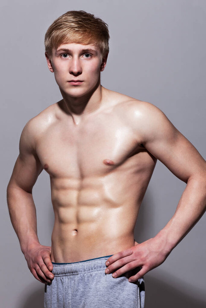 Handsome guy posing with naked torso over background - Fotoğraf, Görsel