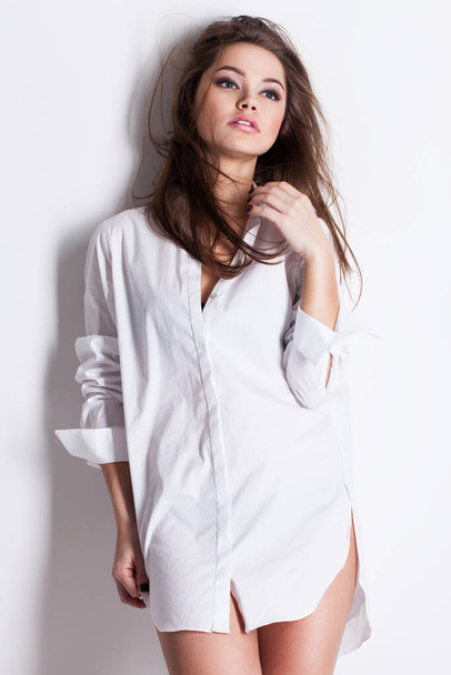 mooie sensuele jonge vrouw in hemd voor mannen op een witte achtergrond - Foto, afbeelding