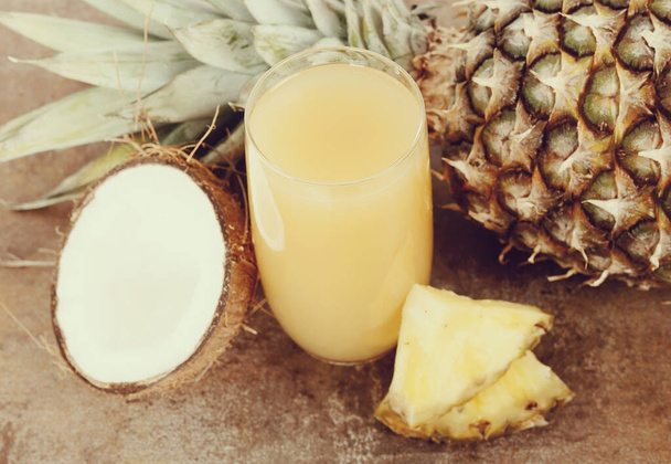 Освежающий ананасовый сок на столе - Фото, изображение