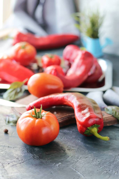 Ντομάτες και πιπεριές κόκκινων λαχανικών, μπαχαρικά στο τραπέζι, κορυφαία άποψη, έννοια υγιεινών εποχιακών τροφίμων, σπιτικό φαγητό - Φωτογραφία, εικόνα