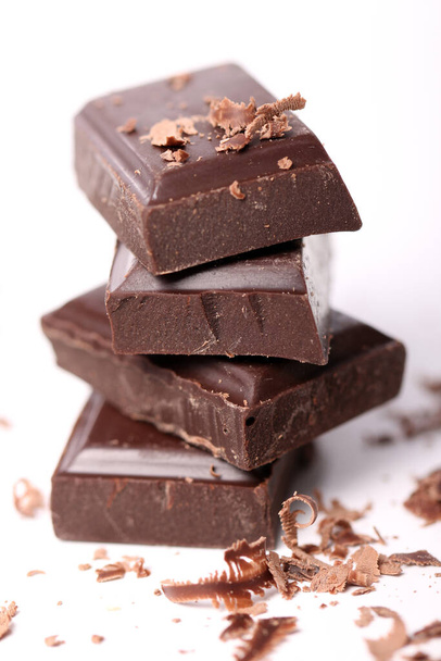 Кусочки черного шоколада на белом фоне - Фото, изображение