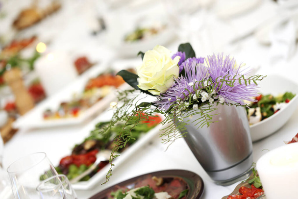 Grande mesa de jantar com flores e muitos tipos diferentes de comida em uma celebração - Foto, Imagem