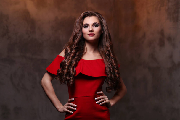 Woman in red dress with gorgeous, curly hairdo - Photo, Image