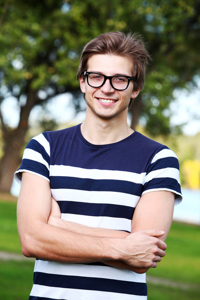 Portrait of young cute man posing in the park - Foto, Imagem