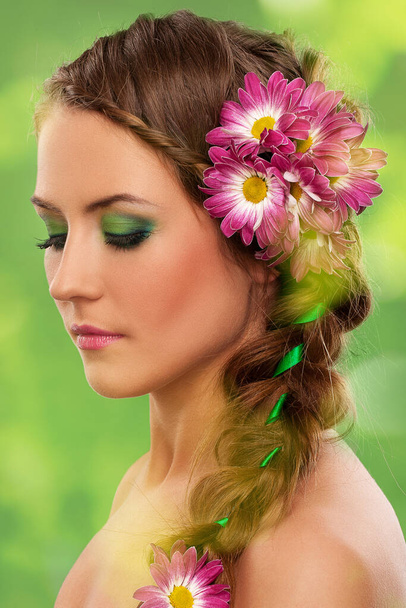 Beautiful woman with makeup and flowers over green background - Photo, Image