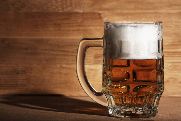 Szklanka zimnego piwa nad drewnianą powierzchnią - Zdjęcie, obraz