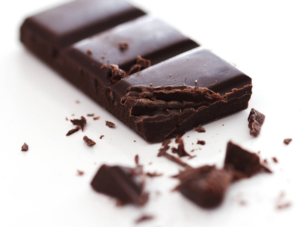 Pieces of black chocolate against white background - Zdjęcie, obraz