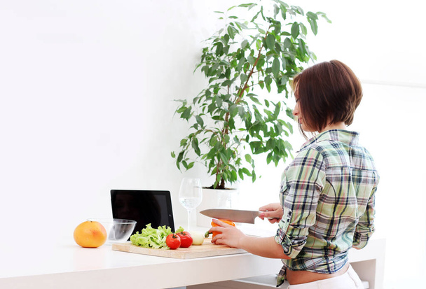 Happy woman preparing a healthy salad at home - Foto, imagen
