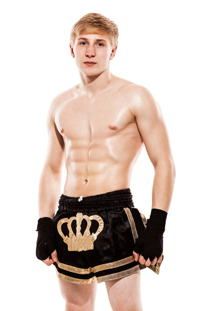 Young handsome fighter in shorts isolated over white baqckground - 写真・画像