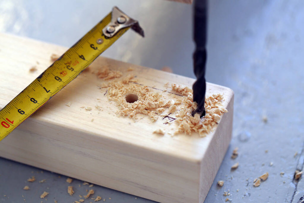 Closeup pictures of a wooden bar being drilled and measured - Photo, Image